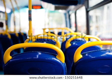 Inside a double decker bus empty seats. London, UK. Interior with yellow and blue chairs and seats. 