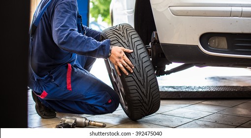 Inside a garage - changing wheels/tires (shallow DOF; color toned image) - Shutterstock ID 392475040