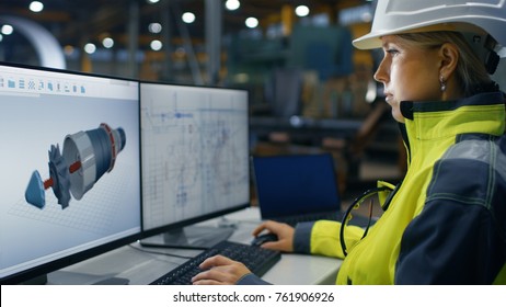 Inside The Heavy Industry Factory Female Industrial Engineer Works On The Personal Computer On The Turbine/ Engine Project In 3D Using CAD Program.