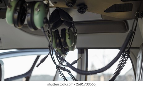 Inside the helicopter, headsets dangle from the ceiling for flight operations and safety.