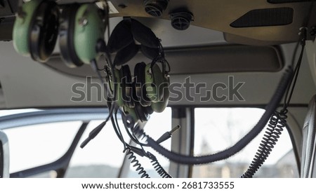 Inside the helicopter, headsets dangle from the ceiling for flight operations and safety.