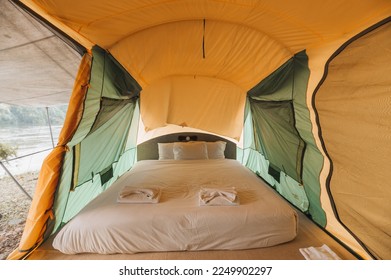 Inside of large comfortable camping tent on campground in the tropical forest by riverside on summer vacation - Powered by Shutterstock