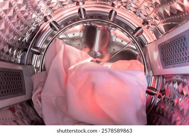 Inside the laundry. A view from inside a washing machine drum, showing colorful clothes, including knits. 