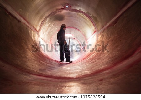 Inside male worker into the inspection shiny tank stainless chemical into area confined space.