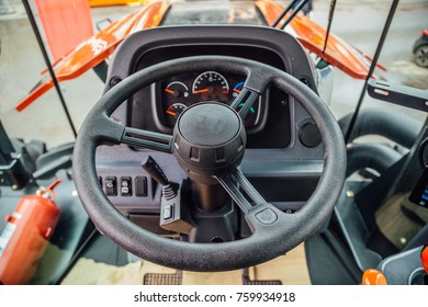 Inside Modern Agricultural Tractor Or Harvester Combine Machine. Steering Wheel. View From Work Place.