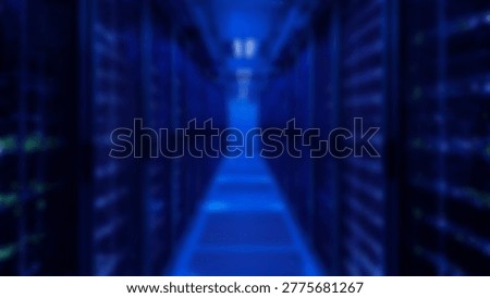 Inside a modern data center, rows of servers are illuminated by blue lights, showcasing advanced technology and data storage capabilities. This image represents the digital age.