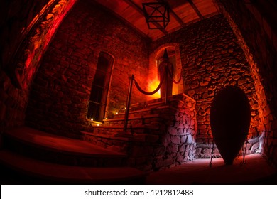 Inside of old creepy abandoned mansion. Silhouette of horror ghost standing on castle stairs to the basement. Spooky dungeon stone stairs in old castle with light. Horror Halloween concept - Powered by Shutterstock