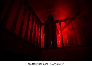 Inside of old creepy abandoned mansion. Silhouette of horror ghost standing on castle stairs to the basement. Horror Halloween concept