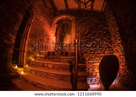 Inside of old creepy abandoned mansion. Silhouette of horror ghost standing on castle stairs to the basement. Spooky dungeon stone stairs in old castle with light. Horror Halloween concept