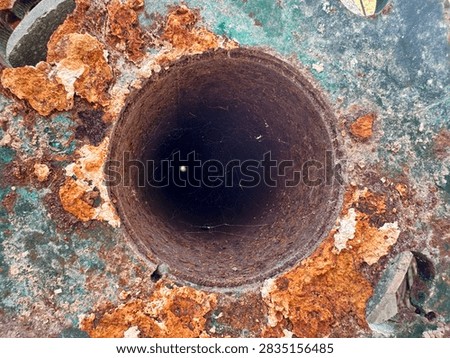 Inside of old rusty pipe with spider web close up.