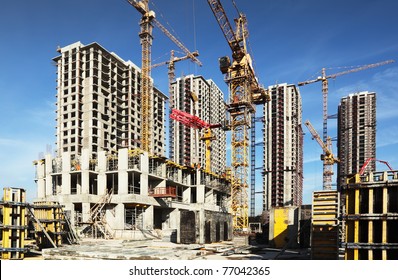 Inside place for many tall buildings under construction and cranes under a blue sky