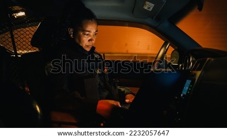 Inside Police Traffic Patrol Squad Car: Black Female Police Officer on Duty Uses Laptop to Check Crime Suspect Background, License Plate, License and Registration. Officer of the Law Fight Crime