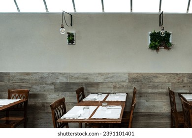 Inside a restaurant, set of table with chairs next to the wall with decoration