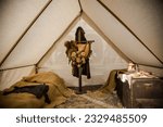 Inside a Roman camp tent, a straw bed, a trunk of skins, and an armor shelf evoke the ambiance of ancient times.