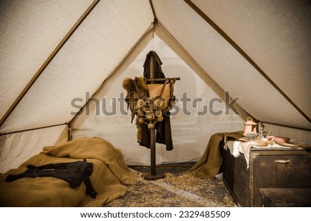 Inside a Roman camp tent, a straw bed, a trunk of skins, and an armor shelf evoke the ambiance of ancient times. Stock foto © 
