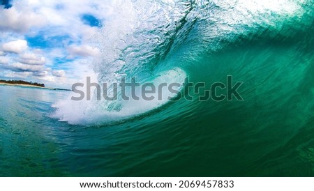 inside the sea waves in a sunny day in day time and green blue sea water with cloudy sky.