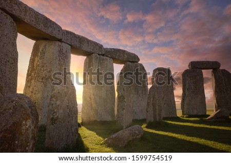 Inside the Stonehenge Circle of Stones with a Dramatic Sky Sunrise behind it