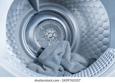 Inside of tumble dryer with clean laundry - new generation of heat pump dryer, household concept - Powered by Shutterstock