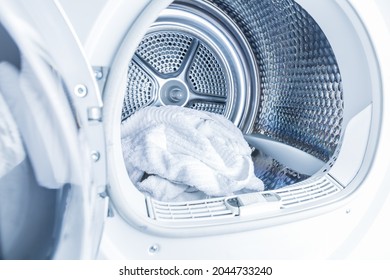Inside of tumble dryer with clean white towels - new generation of dryer,  household concept