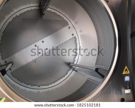 Inside A Tumble Dryer. The drying tank is made of perforated stainless steel for the front-loading tumble dryer. Focus close and choose the subject.