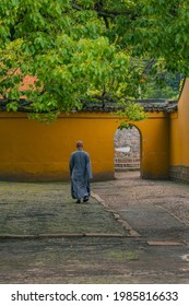 Inside view of a Buddhist temple, with a monk walking.