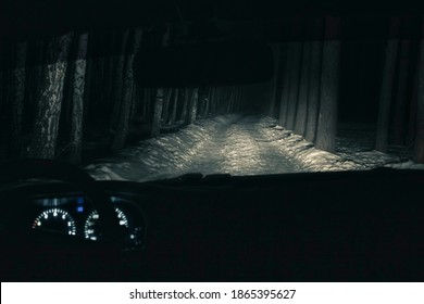 Inside View Of A Car On A Winter Road In The Forest At Night, Front And Background Blurred With Bokeh Effect