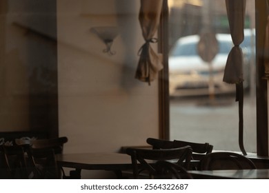 An inside view of a cozy cafe with empty tables, showcasing a reflection of the street outside through the window