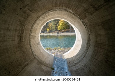 Inside View To The Lake From A Huge Concrete Drainage Pipe For Mountain River Water 