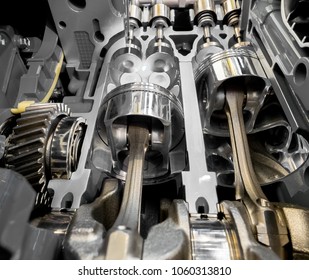 Inside view of modern engine, close up detail of two pistons in cylinder with four valves,some gears aside.