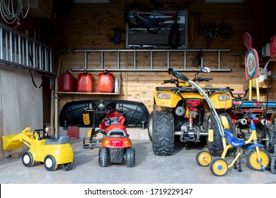 Inside view open door ATV quad bike motorcycle parking messy garage,clutter stuff, children toys and bicylce storage interior at home. House warehouse for tools and equipment . Garage sale facede