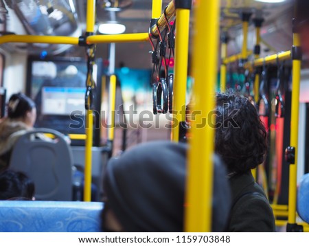 Inside view of passenger cabin of a  shuttle bus with passengers.
