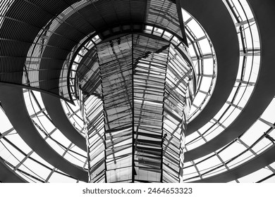 Inside view of the Reichstag glass dome in Berlin showing the mirrored central column and steel framework. Black and white image. - Powered by Shutterstock