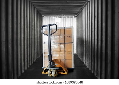 Inside View Of Shipping Container. Cargo Shipment Boxes Stacked On Pallet With Hand Pallet Truck. Industry Cargo Freight Transportation.