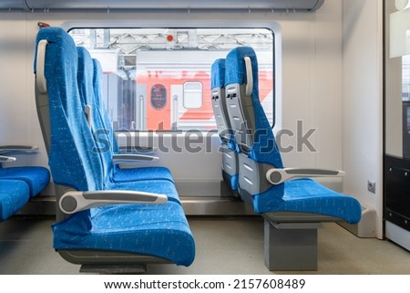 Inside The Wagon Train. Interior of the passenger train with empty blue fabric seats. 