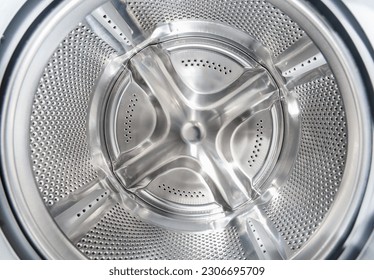 Inside of washing machine. Rotating inner tub. Material metal. Close up of electrical household appliance.