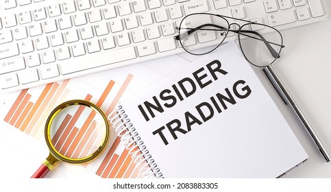INSIDER TRADING text written on notebook with keyboard, chart,and glasses