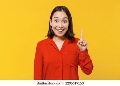 Insighted Smart Proactive Beautiful Fun Young Woman Of Asian Ethnicity 20s Years Old Wears Orange Shirt Holding Index Finger Up With Great New Idea Isolated On Plain Yellow Background Studio Portrait