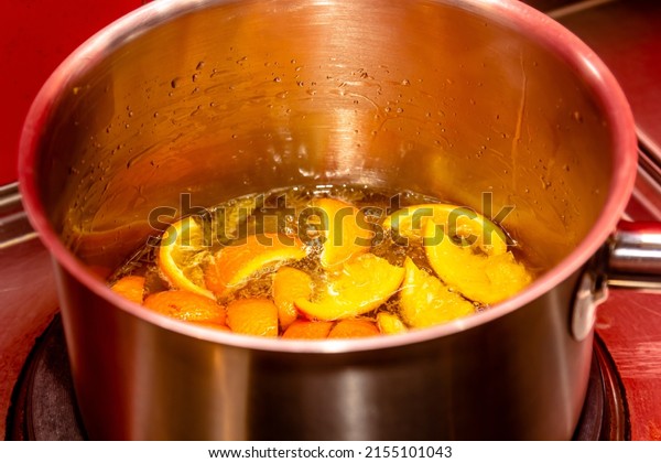 insisting of tangerine jam (varenye) in sugar\
syrup in stewpot on hob at home\
kitchen.