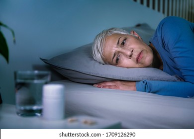 Insomnia And Sleeping Pills That Do Not Work. Mature Woman With Sleeping Problems Awake In The Middle Of The Night