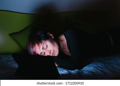 Insomnia And Sleeplessness Lifestyle. Young Caucasian Woman Sleeping Watching Tv In Bed. People Hooked Up With Entertainment Devices Before Going To Bed. Technology And Leisure Concept.