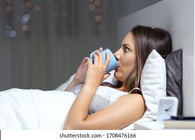 Insomniac Woman Drinking Coffee Cup With Eyes Wide Open Lying In Bed At Night