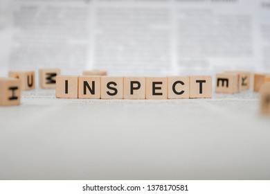 Inspect Word Written In Wooden Cube - Newspaper 