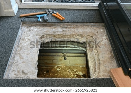 Inspecting indoor crawl space with flashlight