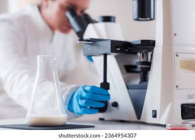 Inspecting milk samples under a microscope in a lab