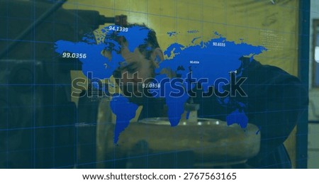 Inspecting technician in dark jacket leaning over bench in workshop, with blue map and metal part. Machinery, engineering, focus, gridlines, overlay, cylinder, precision