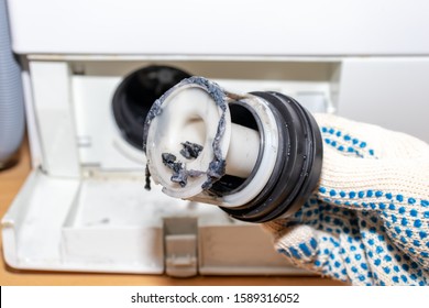 Inspecting Washing Machine's Dirty Clogged Drain Pump Filter Close Up, Clean And Repair.