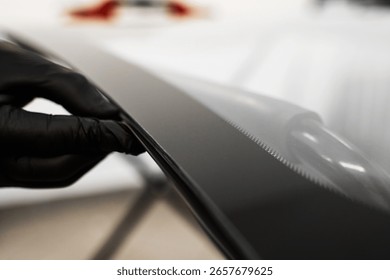 Inspecting the windshield edge before applying adhesive for seamless car glass installation. Windshield Edge Sealing Preparation. Technician prepares car windshield edge for installation