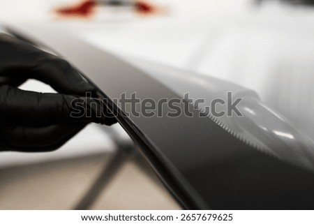 Inspecting the windshield edge before applying adhesive for seamless car glass installation. Windshield Edge Sealing Preparation. Technician prepares car windshield edge for installation
