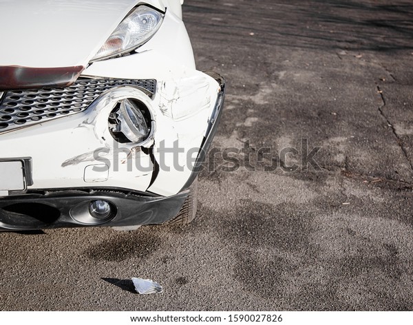 Inspection of the car after an accident on the\
road. Car accident or accident. The front wing and the right\
headlight are broken, damage and scratches on the bumper. Broken\
car parts or\
close-up.