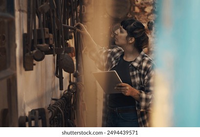 Inspection, confident and woman with tablet, workshop and proud of gender equality in foundry and blacksmith. Hardworking, apron and manufacturing in factory, person and skills for welding and tools - Powered by Shutterstock